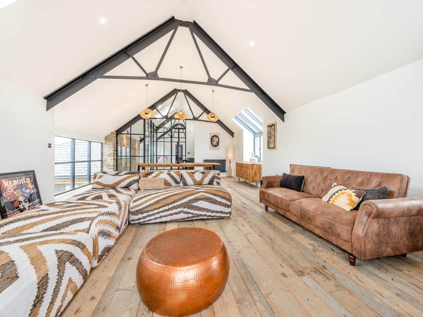Open-plan living space under vaulted beams