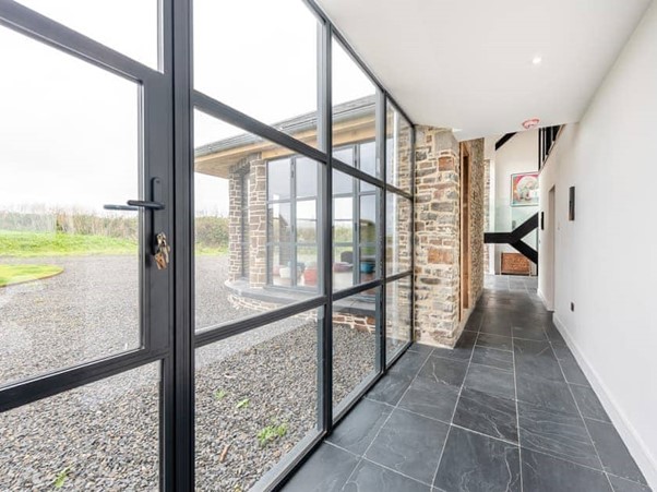 Glazed hallway with slate floor and steel-framed windows