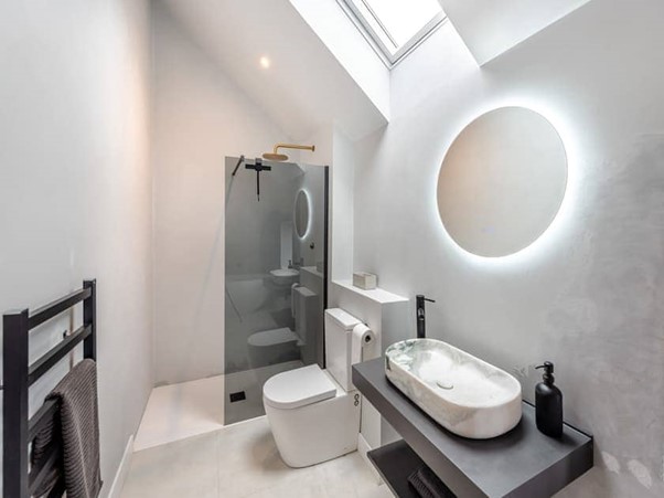 Master ensuite with skylight and round mirror