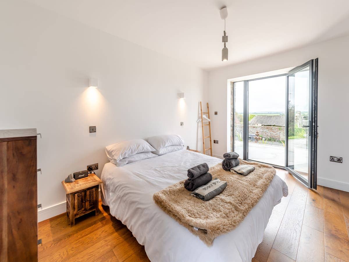 Double bedroom opening onto patio with countryside views
